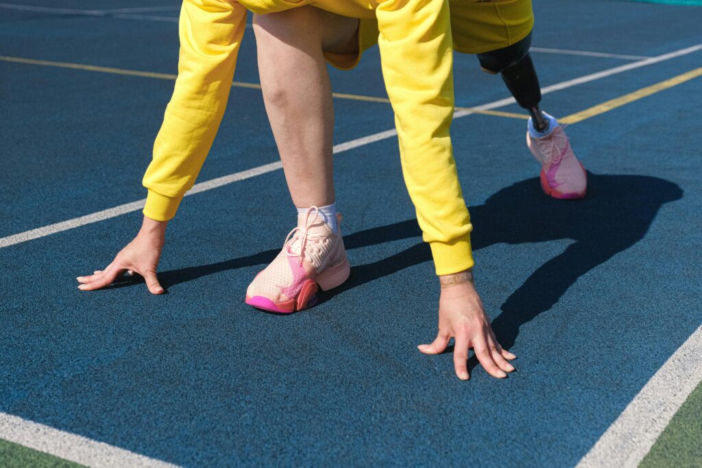 pexels-photo-5069230-5069230 Female athlete with a prosthetic leg preparing to run on an outdoor track.