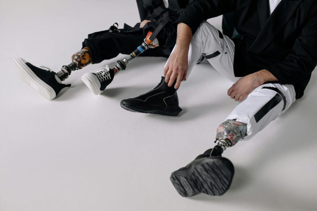 pexels-photo-6153562-6153562 Stylish individuals showcasing prosthetic legs in a modern indoor setting.