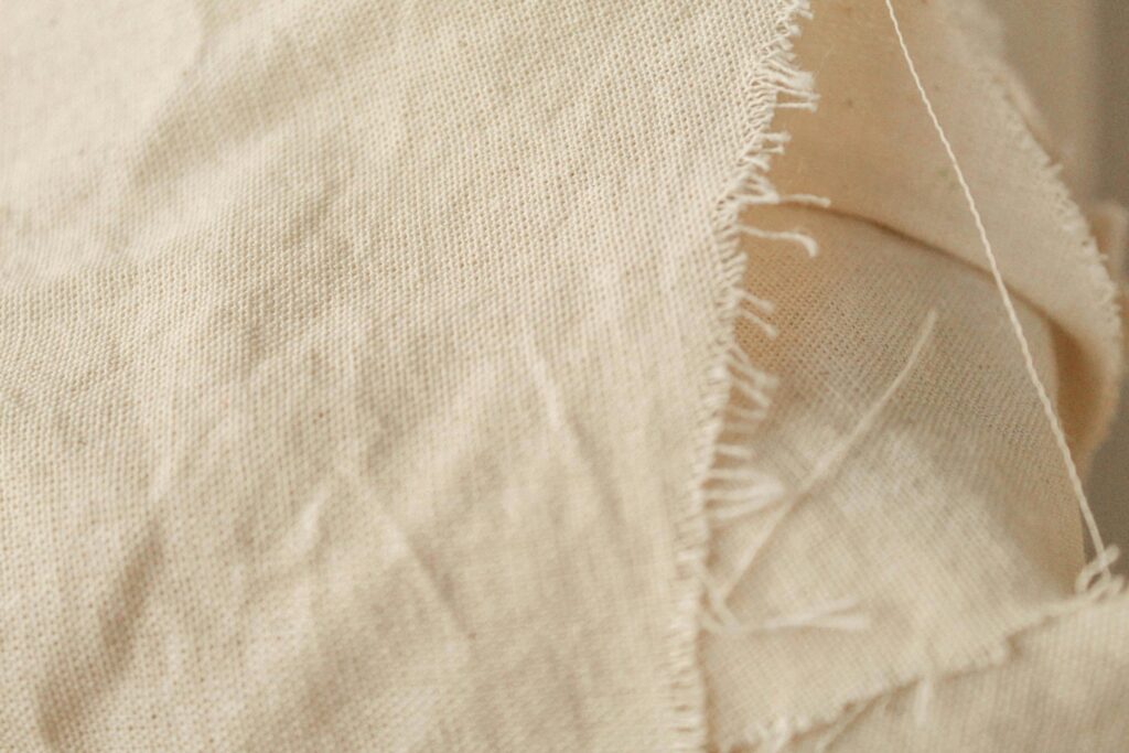 pexels-photo-7533973-7533973 Detailed close-up of beige fabric showcasing frayed edges and texture, ideal for design and textile references.
